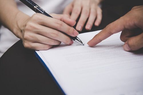 Hand signing an agreement.